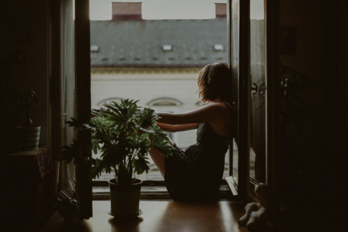 Frau sitzt am Fenster